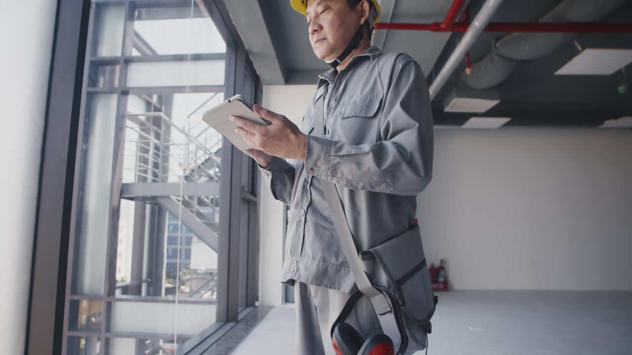 Portrait of Adult Asian Man Checking Tablet at Construction Site