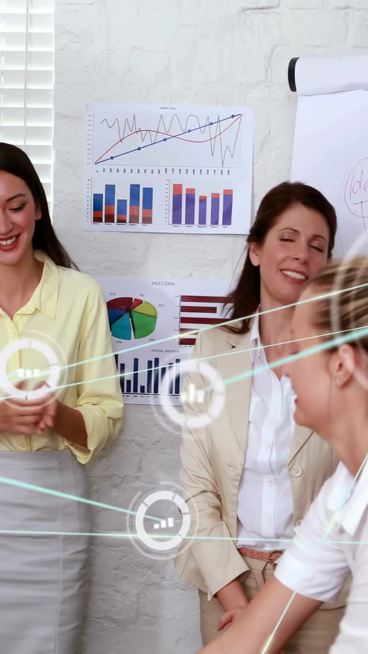 Video verticale: Due donne in ufficio che reagiscono a un presentatore mentre icone scorrono su grafici che mostrano dati.