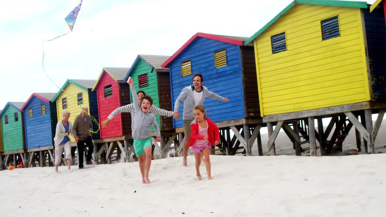 familia de varias generaciones volando cometas en la playa