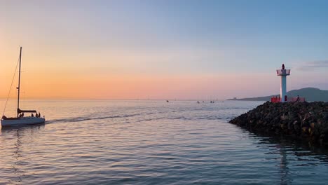 sailing boats arriving at howth harbor at golden hour