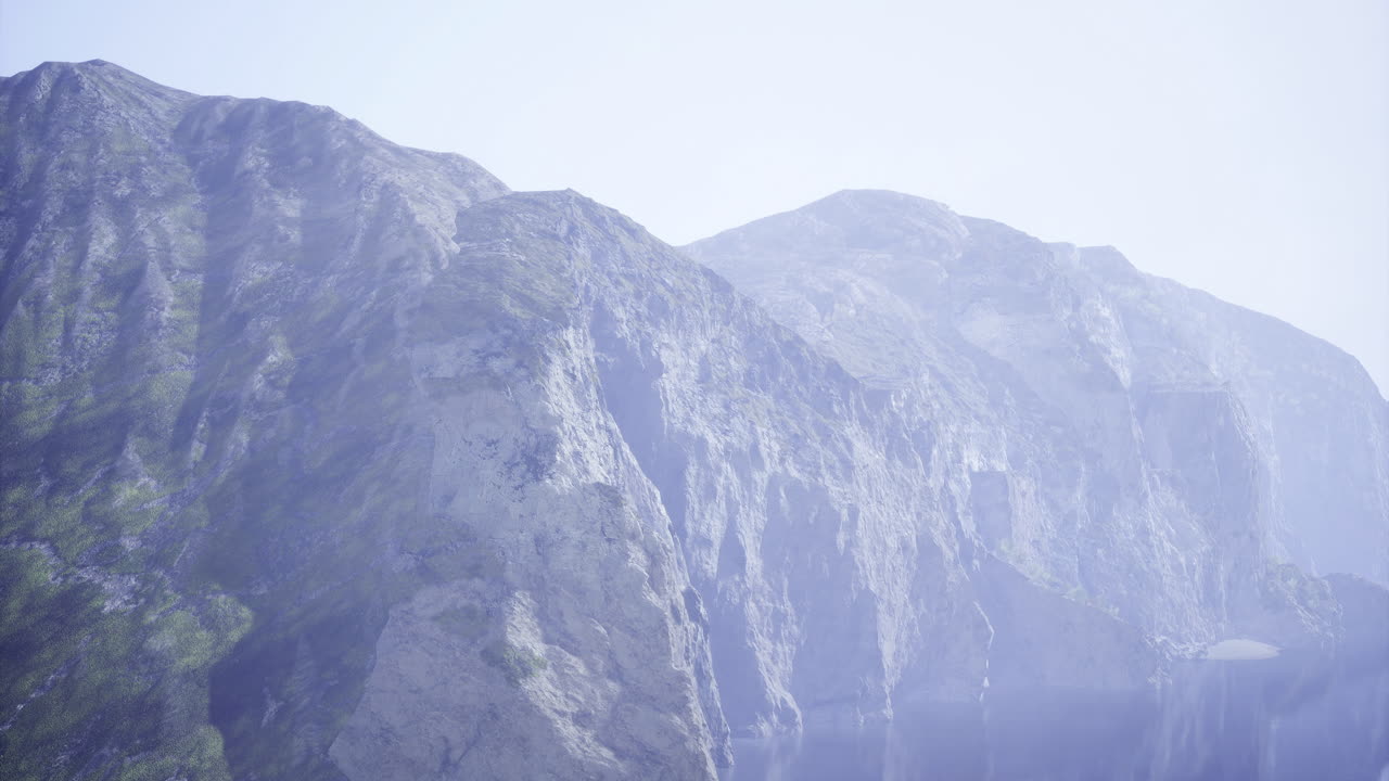 Majestic mountains rising above a serene lake under a clear sky