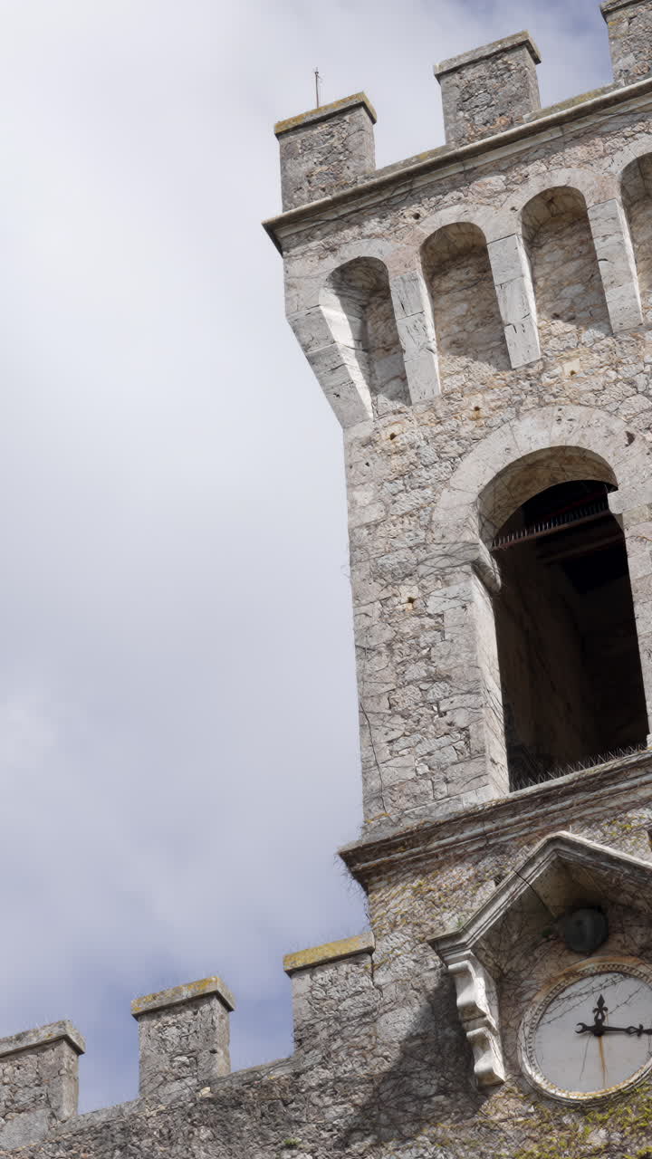 Stone Castle Tower with Clock against a Cloudy Sky