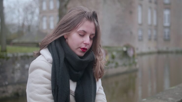 Beautiful sad young blond girl gently crying and rubbing her eyes