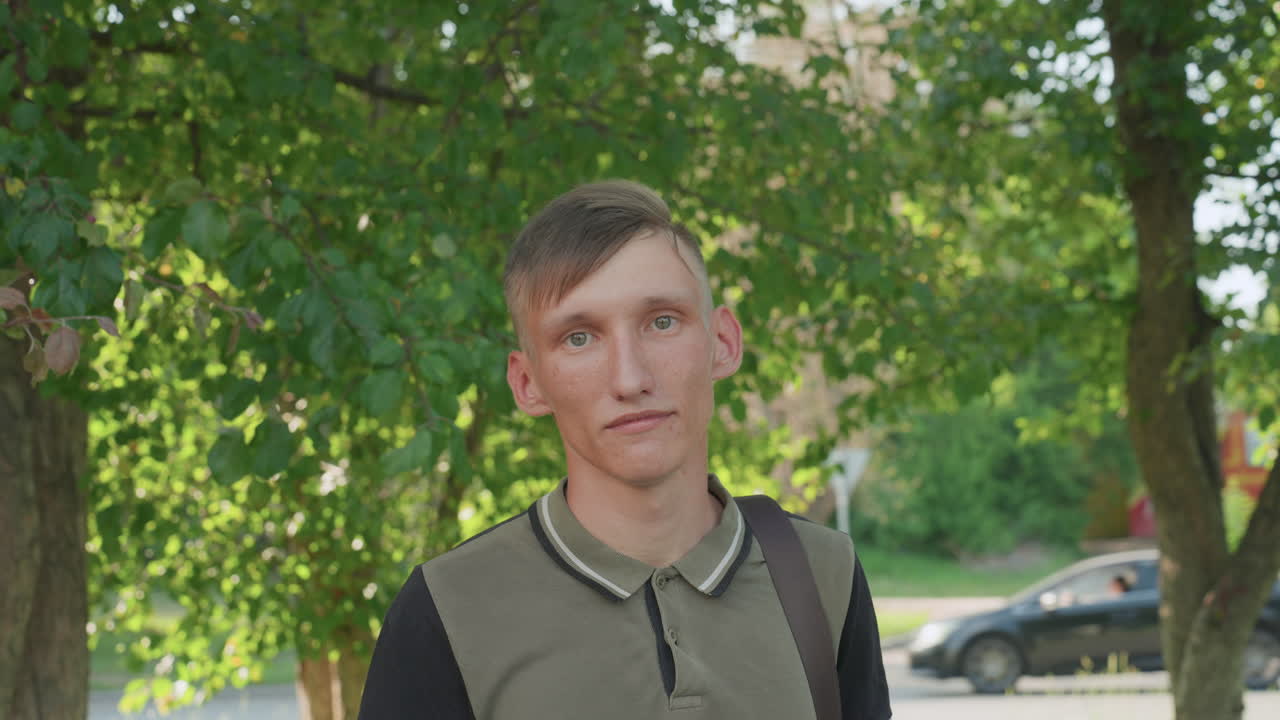 Casual Thoughtful Photograph, Portrait Of Individual Beneath Expansive Tree With Calm Ambiance, Scene Capturing Young Man Gazing Thoughtfully Amidst Lush Greenery And Gentle Natural Light