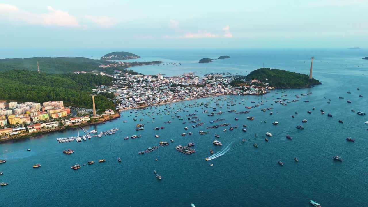 Aerial view of Phu Quoc's fishing village, Vietnam. Boats dot the sea near shore with a cable car line. Captures island life and coastal activity.