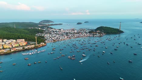 aerial view of phu quoc's fishing village, vietnam. boats dot the sea near shore with a cable car line. captures island life and coastal activity.