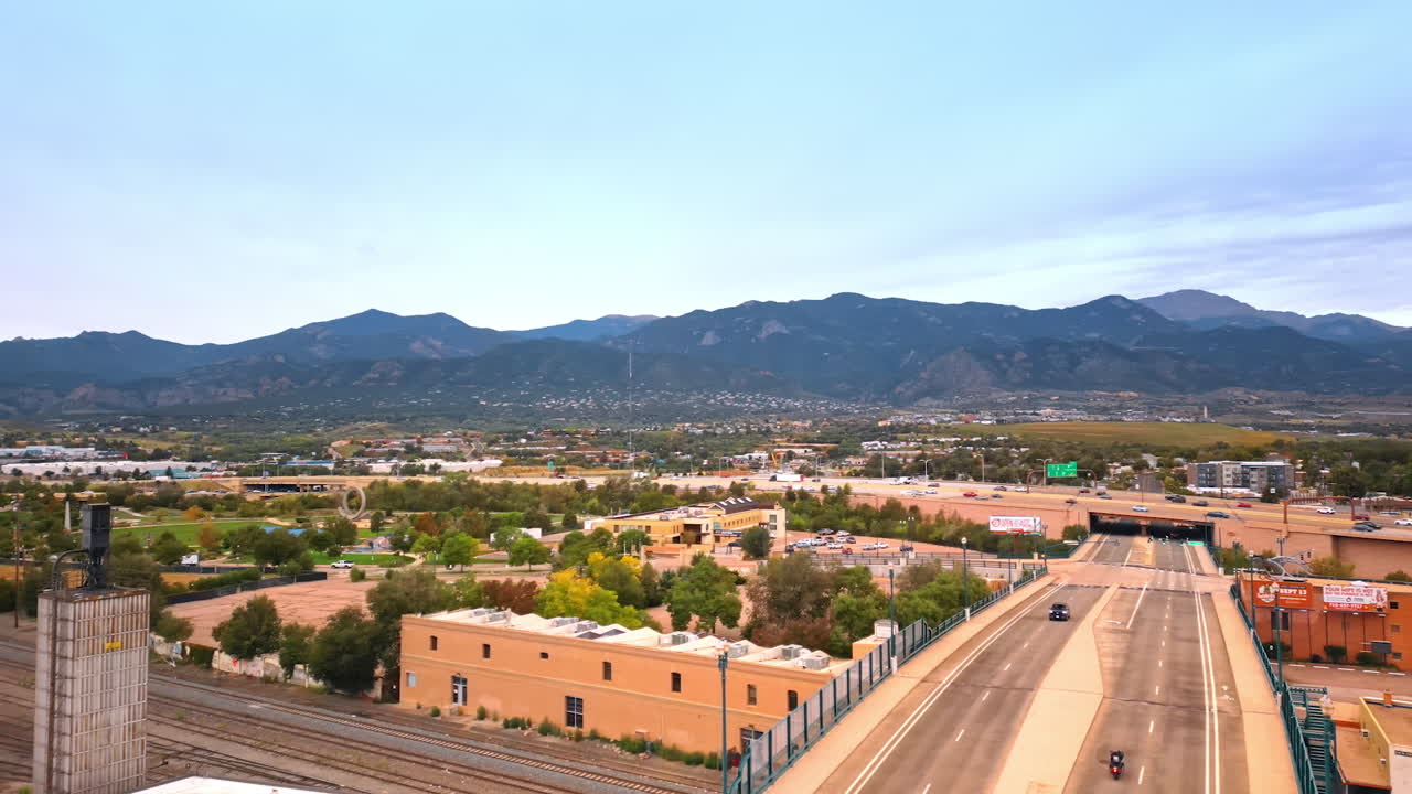 Colorado Springs, USA, 22 July 2025: Wide road and bridge over the railways. Hectic traffic on the highway crossing the cityscape of Colorado-Springs, Colorado, USA. Mountains at backdrop