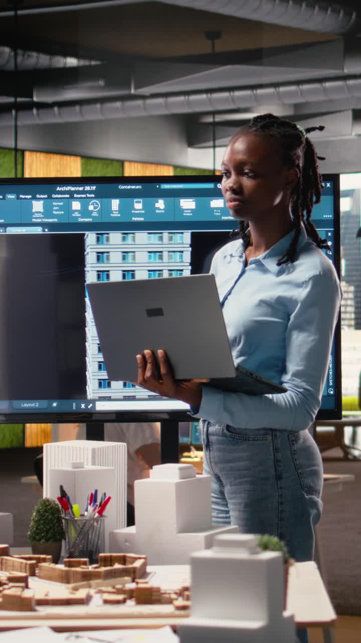 Vertical Video Black female developer reviewing zoning regulations with 3D models