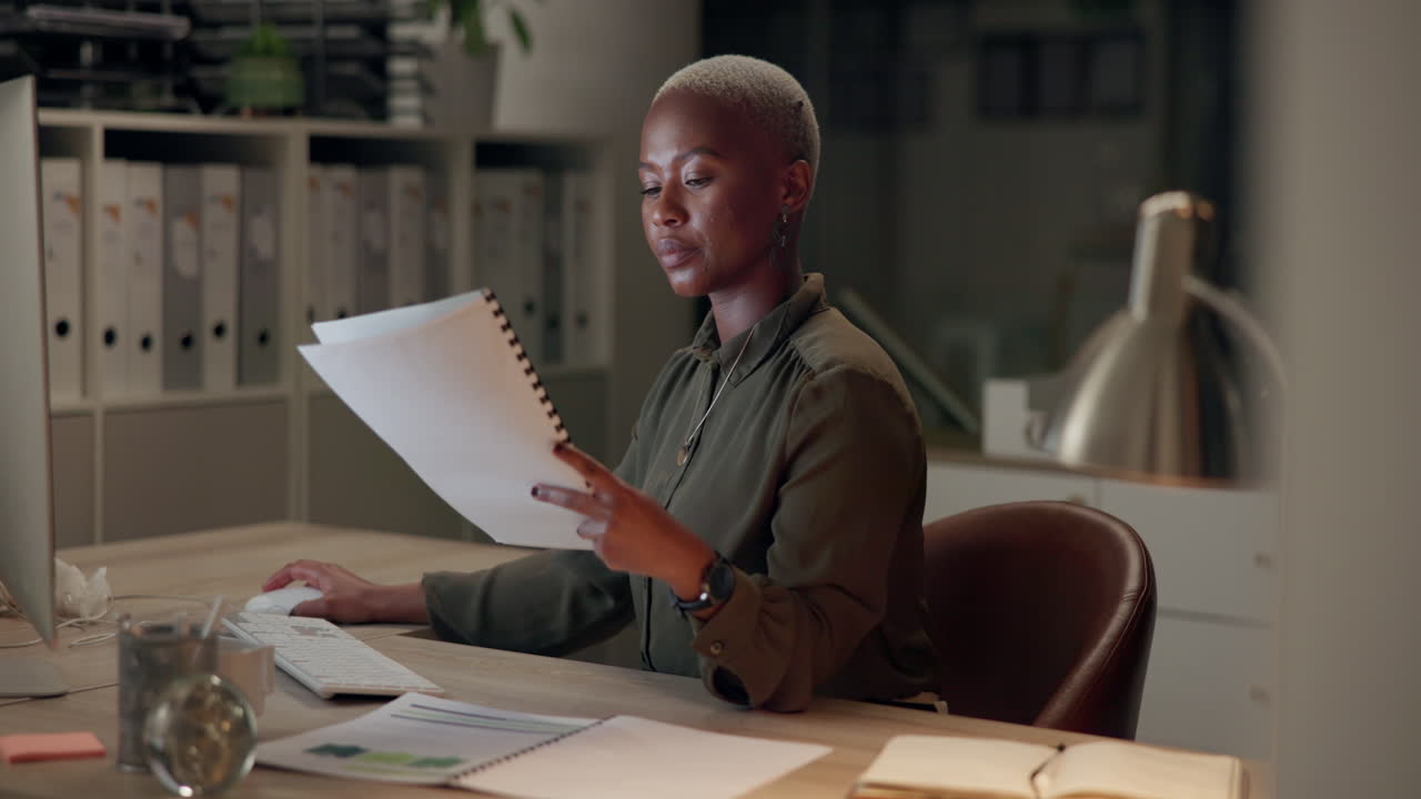 Woman working at her desk in the office at night