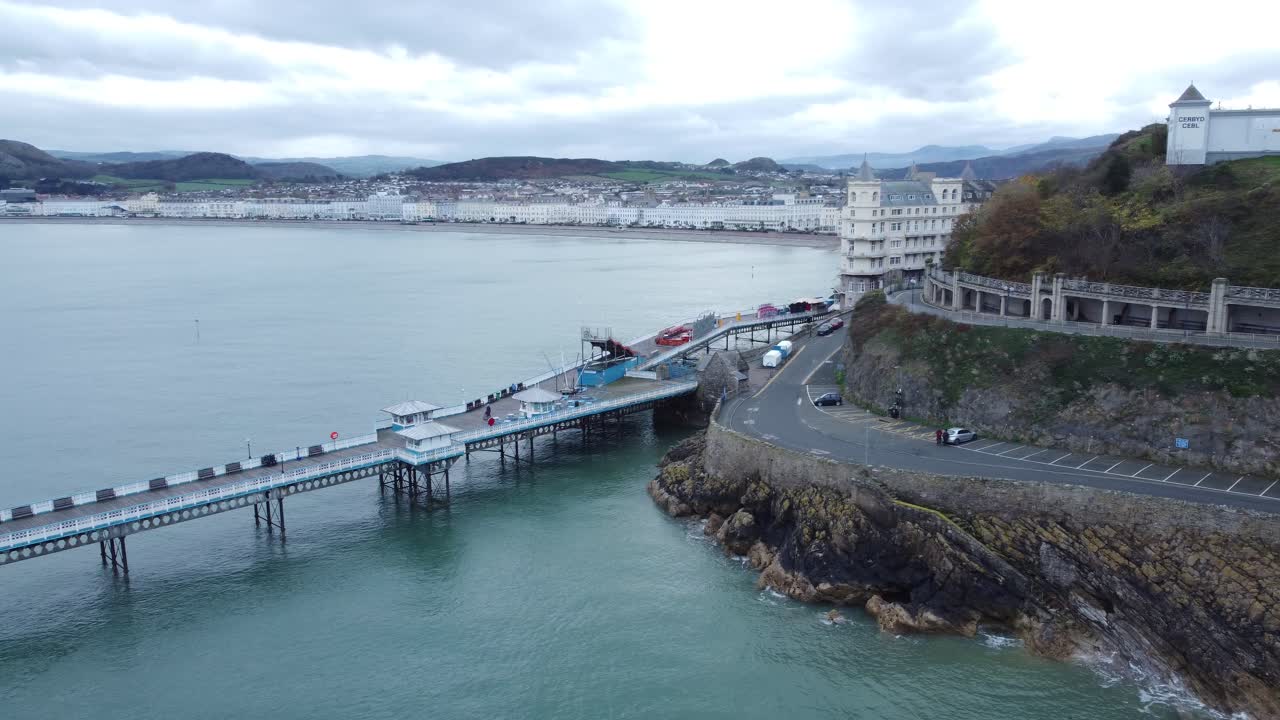 llandudno pier histórico paseo marítimo de madera victoriano punto de referencia junto al mar vista aérea pan izquierda disparó a través del paseo marítimo