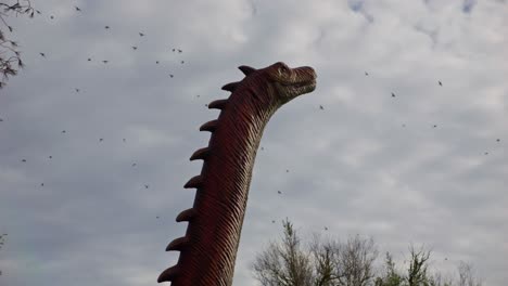 movimiento de la cabeza del diplodocus del bebé del tamaño de la vida de un dinosaurio y pájaros voladores, 4k, 60 fps