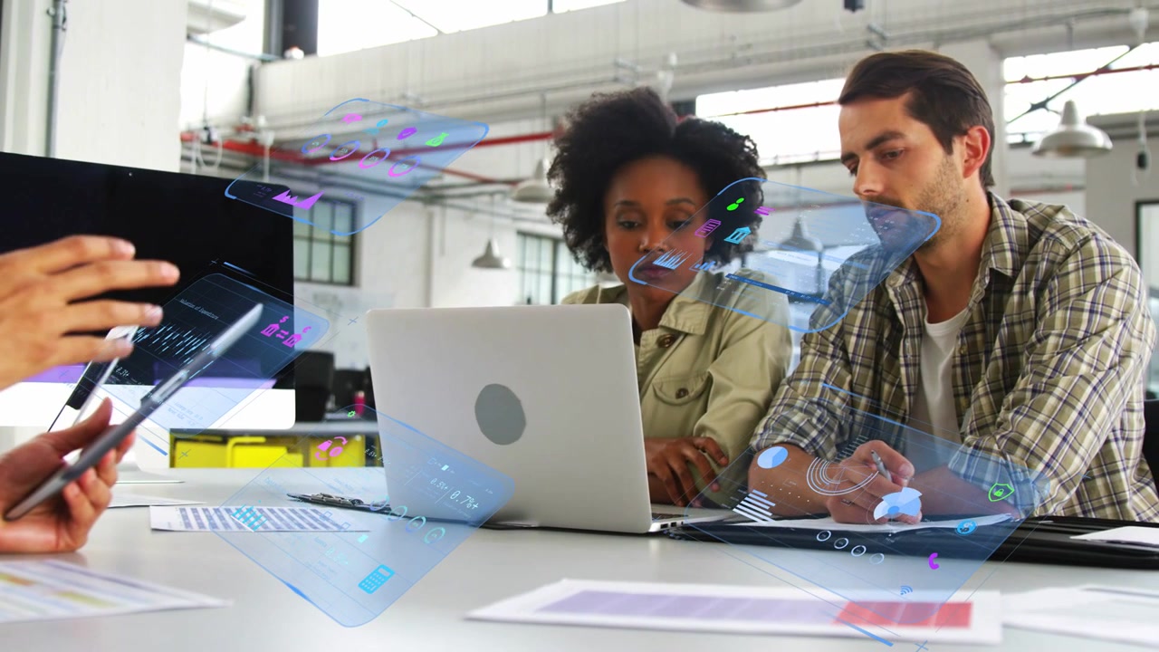 Lead tapping tablet showing AR UI over laptop while pair leaning man using stylus reviewing design