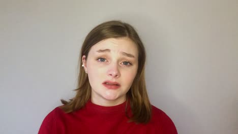 female young student looking visibly concerned while talking to camera on video call