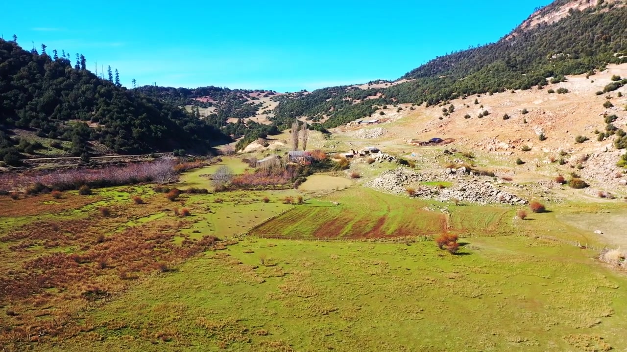Drone luftfoto af marokkanske vådområder med lavt vand, tør vegetation og omkringliggende bakker under en klar blå himmel. Naturskønt landskab ideelt til rejse- og dokumentarprojekter