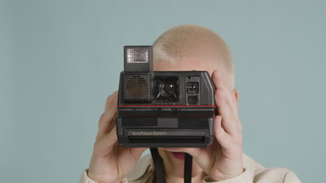 female photographer poses with an instant film camera 02