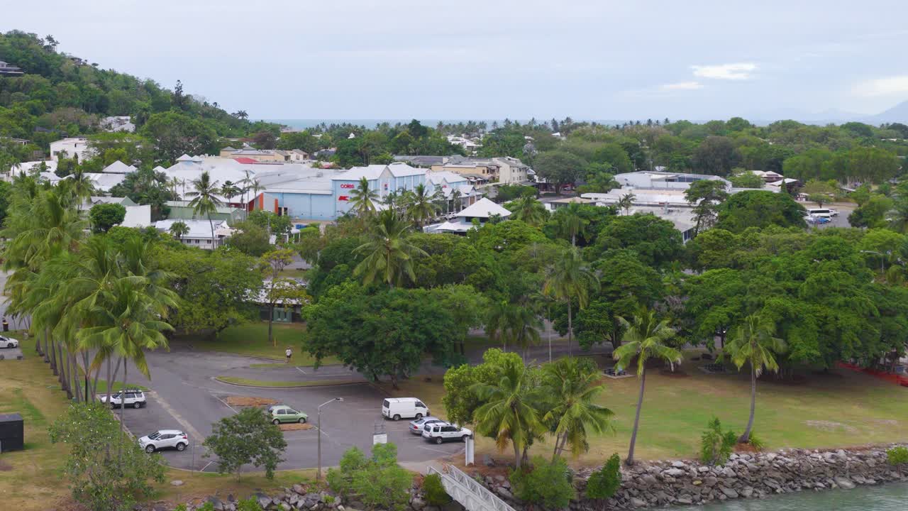 Aerial footage captures the lush greenery and urban layout of Port Douglas, Queensland, under soft daylight