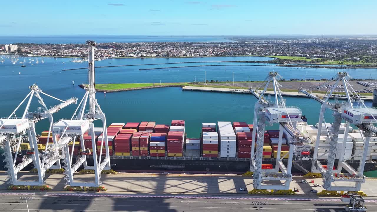 Large cargo ship docked beside cranes at Melbourne container port in Port Phillip Bay