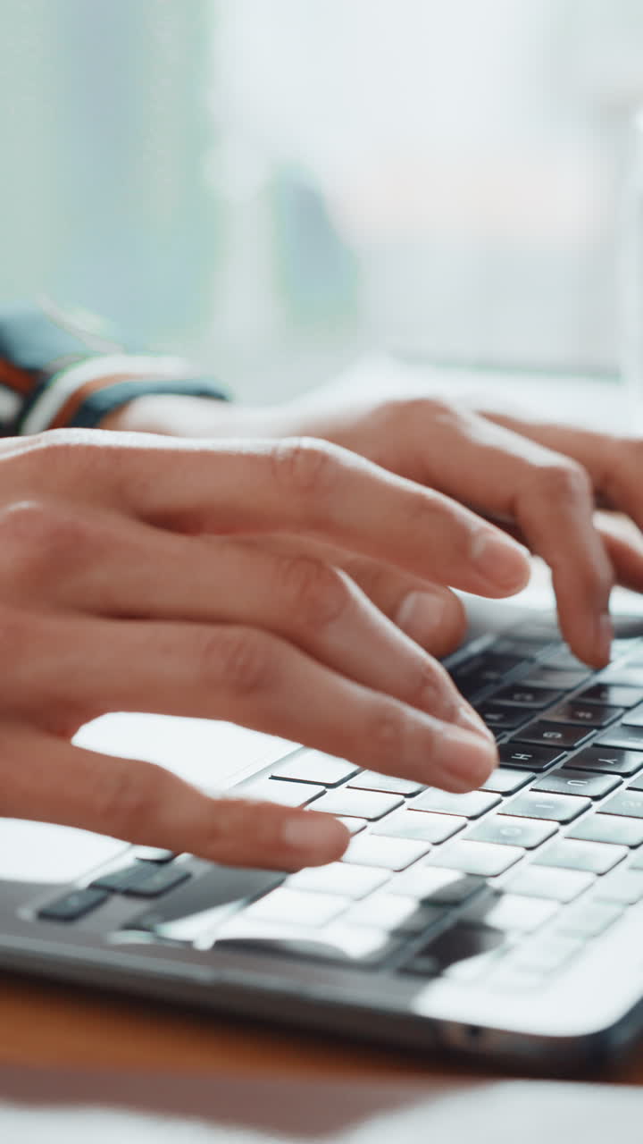 Primo piano di mani che digitano sulla tastiera di un laptop
