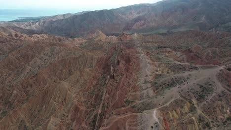 aerial orbit of fairytale canyon skazka, kyrgyzstan, with its vibrant red rock formations and winding trails