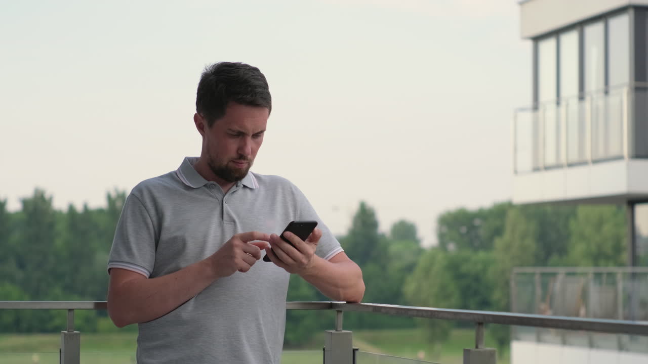 발코니에서 스마트폰을 사용하는 남자