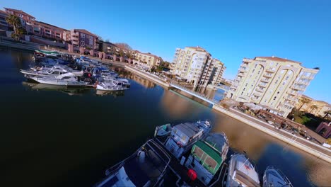 Cinematic-FPV-diving-shot-overhead-port-Ariane-with-boats-docked-in-Lattes,-France