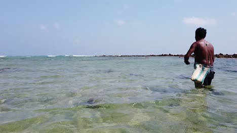 fisherman casts his wire and hook with bait attached into the shallow waters at high tide