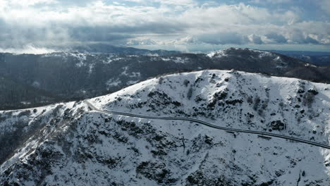 Una-Montaña-Cubierta-De-Nieve-Con-Teleféricos,-Nubes-Al-Fondo,-Vista-Aérea