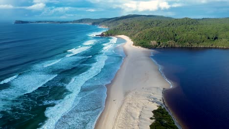 drone aerial landscape of ocean swell waves breaking on sandbar coastline headland with smiths lake channel inlet at cellito beach australia mid-north coast travel surfing tourism nature outdoors town