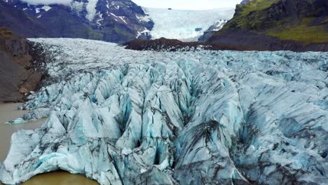 aerial view of svinafellsjokull glacier with blueish cracked ice in iceland