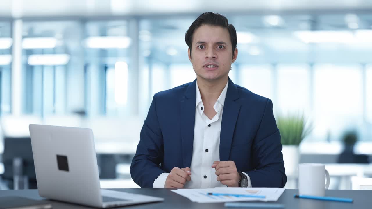 un manager indiano frustrato che urla a qualcuno.