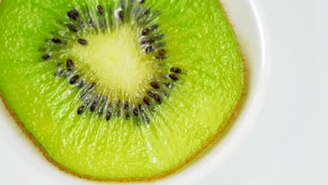 la rebanada de kiwi fresca está girando lentamente en el estudio con los detalles.