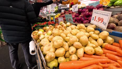 hombre seleccionando verduras en el puesto del mercado