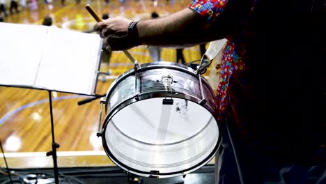 musician playing snare drum while people dance in background