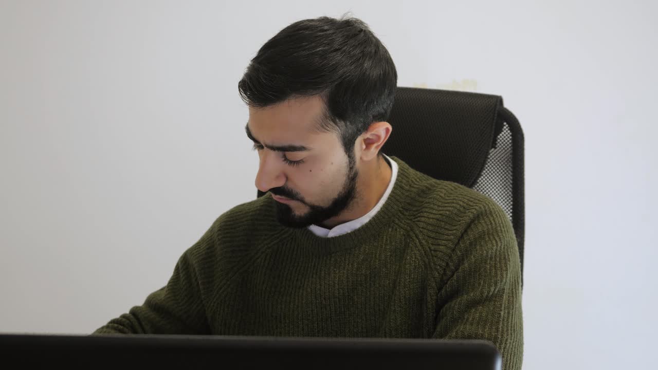 Hombre que trabaja en la computadora portátil en la oficina