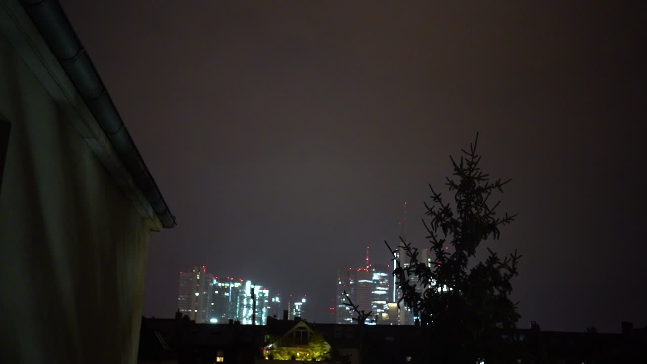 Lightning illuminates the night sky over Frankfurt, highlighting the city skyline