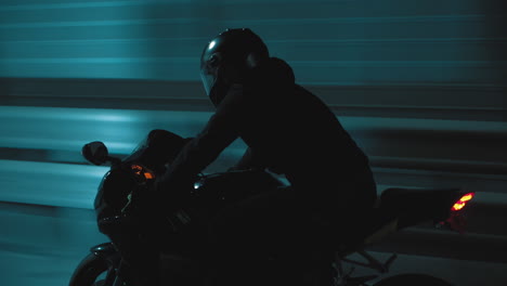 a man rides a sports motorcycle through the city at night