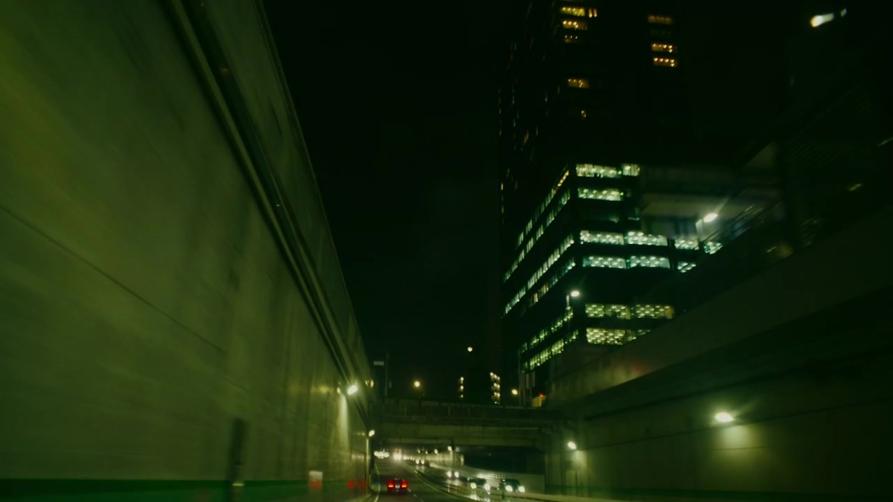 Passaggio sull'autostrada di Tokyo con skyline cittadino illuminato di notte