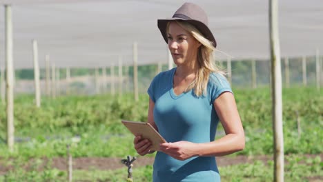 Video-of-caucasian-woman-with-tablet-standing-in-greenhouse