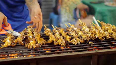 grilled squid on a charcoal stove at yaowarat road chinatown, a popular travel destination in bangkok, thailand