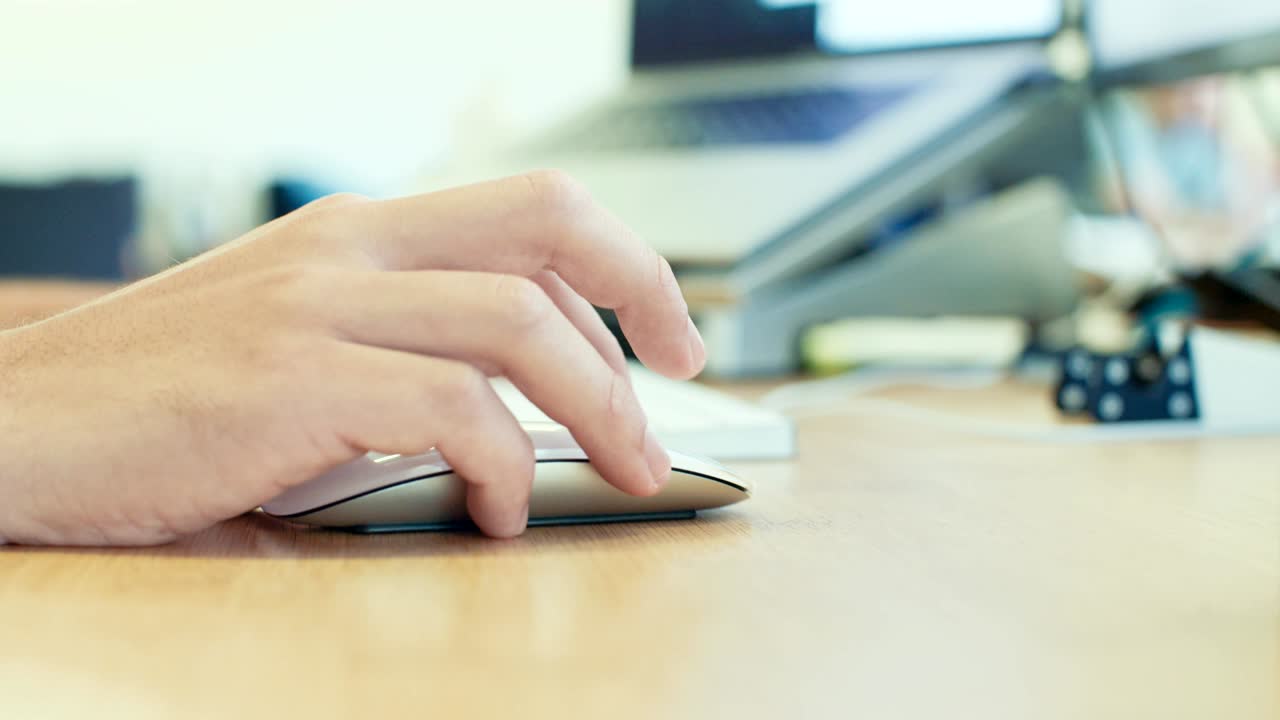 hombre trabajando con un ratón inalámbrico en un escritorio