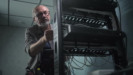 network technician performing maintenance on a server rack