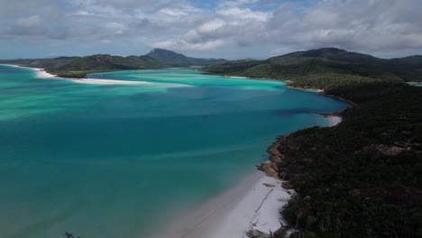 revealing-drone-shot-over-whitehaven-beach-lookout-in-the-whitsundays-on-a-cloudy-day-with-people-walking-on-the-beach,-queensland,-australia