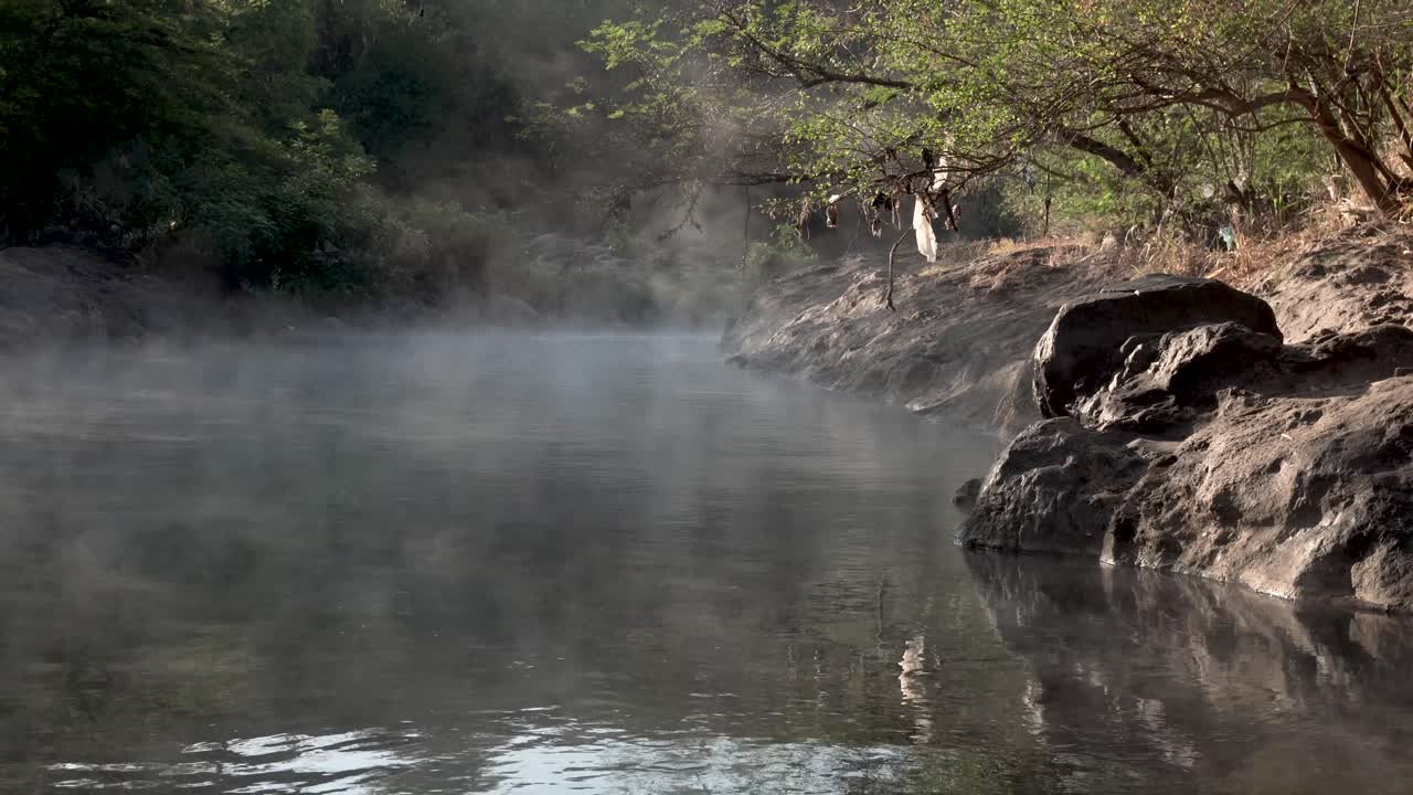 contaminación de bolsas de plástico colgando de las ramas de los árboles en las aguas del río manantial geotérmico del río caliente el salvador, tiro de mano
