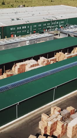 warehouse of plant manufacturing parquet. aerial view. camera motion to left vertical video