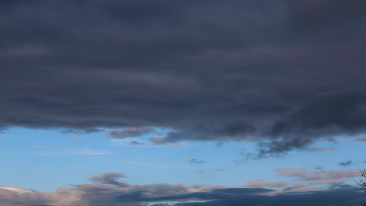 파란 하늘의 줄무에 빠르게 움직이는 어두운 구름의 타임 스 비디오