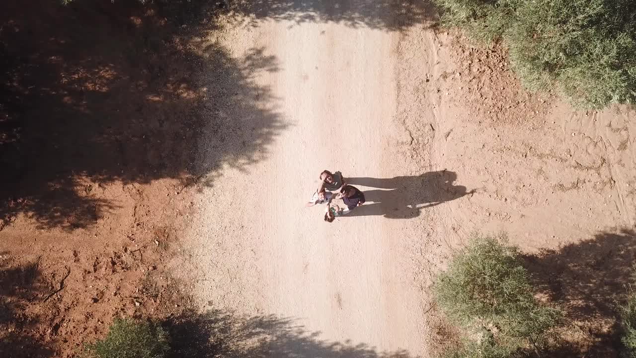 Drone che si alza mentre una famiglia saluta la telecamera in mezzo a un sentiero