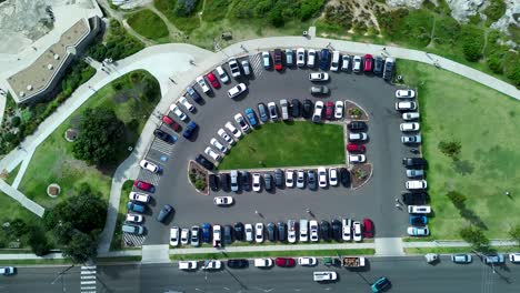 Drone-aerial-South-Coogee-cars-parking-driving-in-carpark-upon-street-road-coast-headland-transportation-Maroubra-Randwick-Sydney-Australia