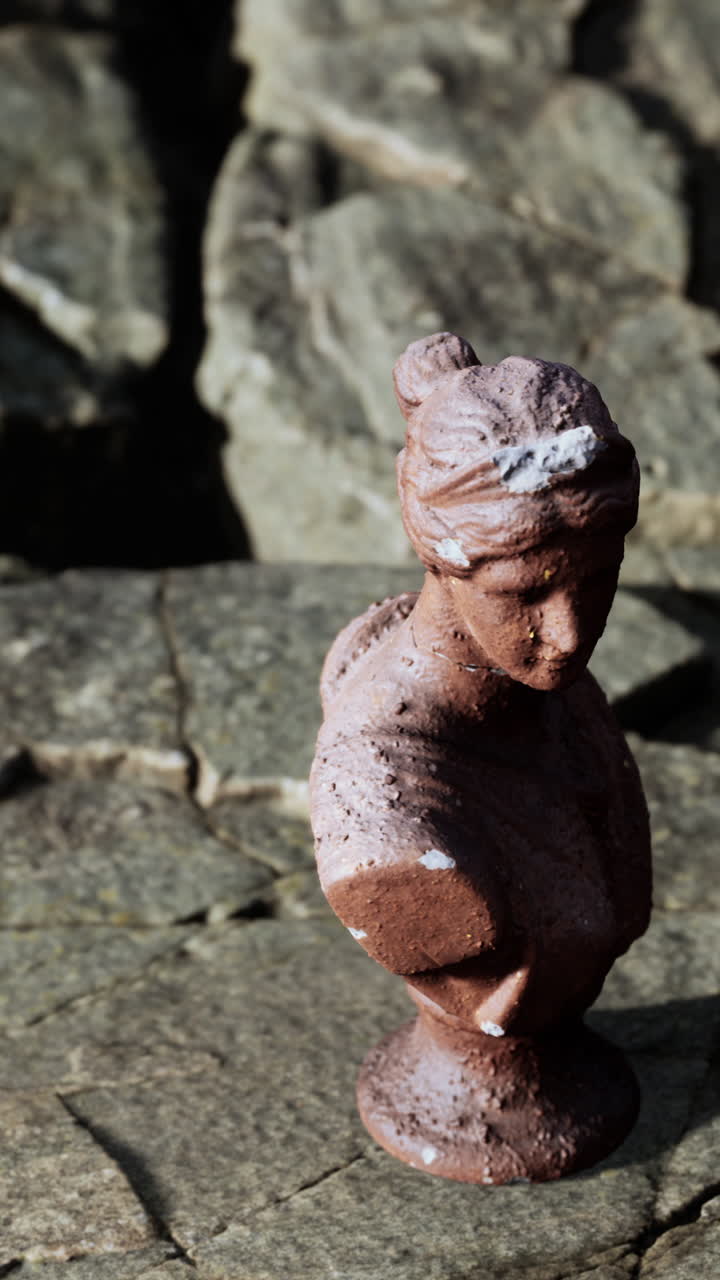 바위 표면 에 있는 여자 의 부스트 의 작은 동상 의 클로즈업