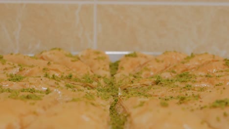 khavuch baklava turca con pistacho aplastado en un molino. primer plano. disparo de dolly. 4k