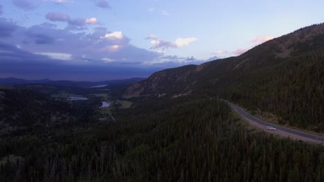 Luftaufnahme-Der-Straße,-Die-Den-Berg-Hinunterführt,-Luftaufnahme-Der-Colorado-Landschaft-Bei-Sonnenuntergang,-Straße-Durch-Felsige-Berge,-Die-Zum-Stausee-Führt